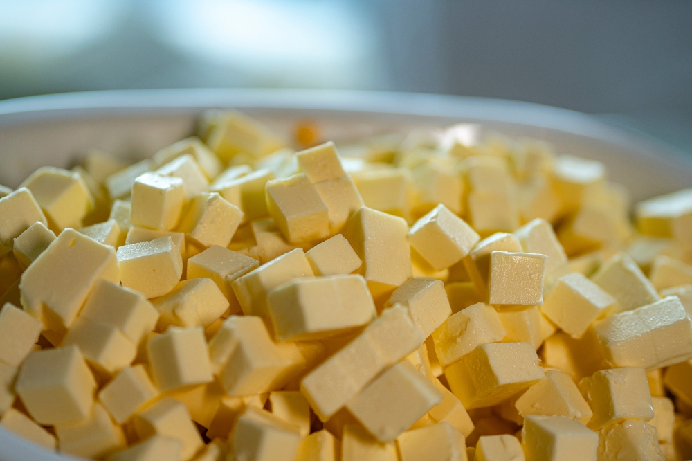 Pieces of butter A bowl of yellow butter cubes. To make butter cubes, take a frozen block of butter and place it on a chopping board.
