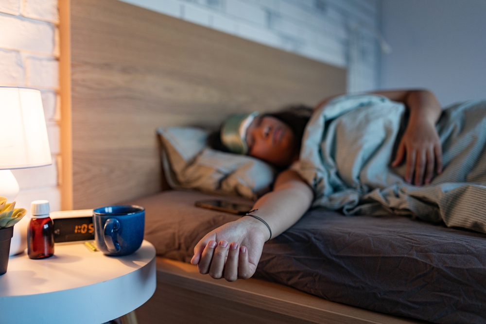 Woman sleeping with sleep mask, using sleeping pills, melatonin. Concept of sleep routine. Insomnia a sleep problems among adults.