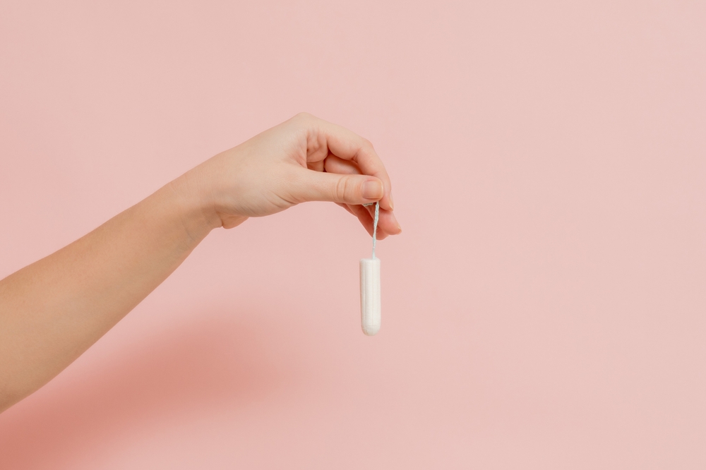 Hand holding a medical feminine tampon. Cotton swab. Menstruation
