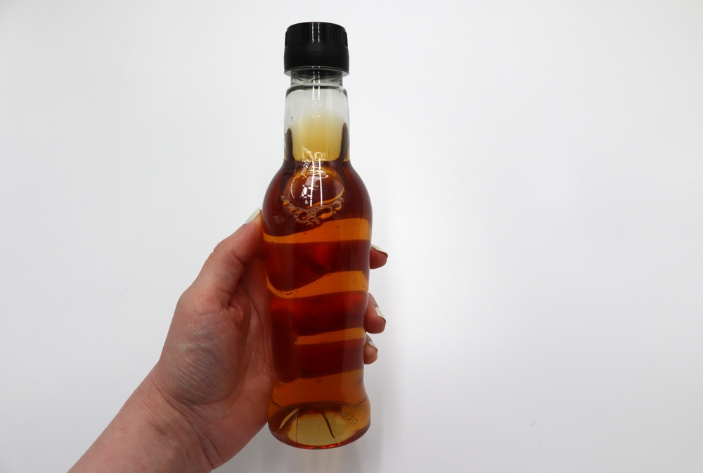 Apple cider vinegar bottle for health benefits on white background