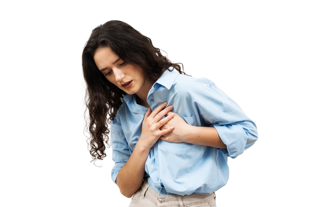 Attractive Woman Touches Her Hand to her Heart. Heart Attack Pain. CHD Coronary Heart Disease Its Heart Blood Supply Blocked By Fatty Substances In The Coronary Arteries