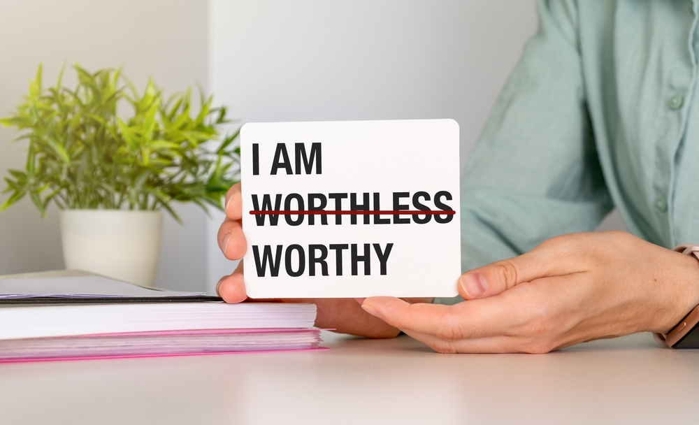 Note stick on copy space background with text I AM WORTHLESS change to I AM WORTHY, concept of self talk affirmation to overcome low self esteem, to love and accept value of oneself

