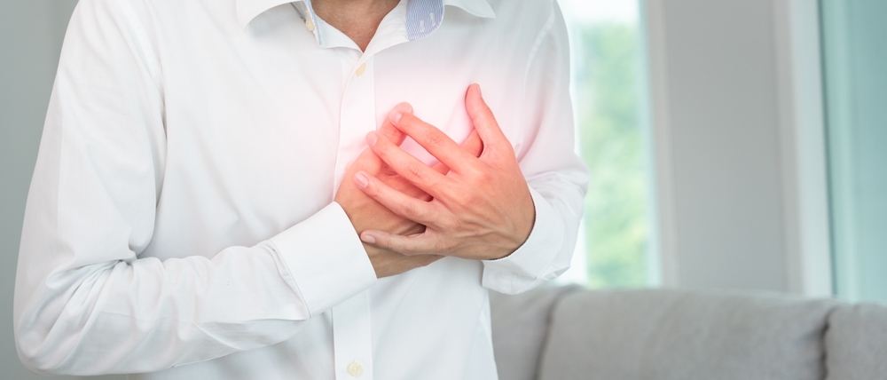 hand hold chest with heart attack symptoms, asian man working hard have chest pain caused by heart disease, leak, dilatation, enlarged coronary heart, press on the chest with a painful expression
