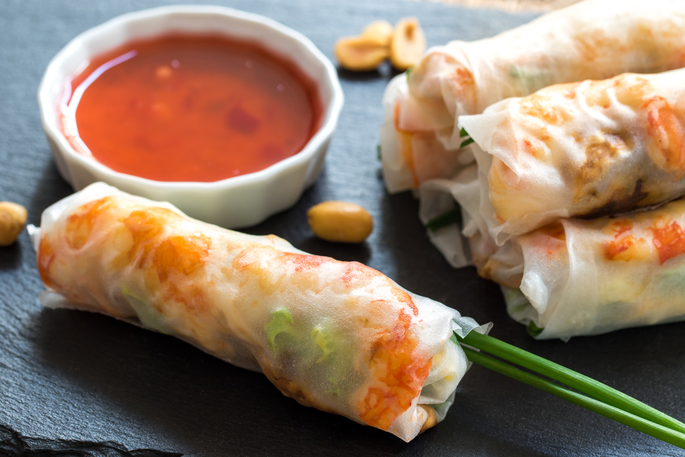 Macro close up of chicken and prawn Vietnamese rice rolls served with bittersweet sauce.