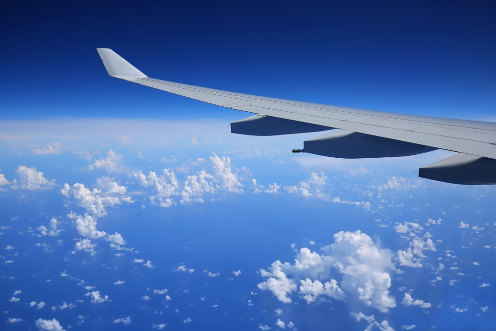 Airplane flies over an unusual formation of clouds forming a circle.