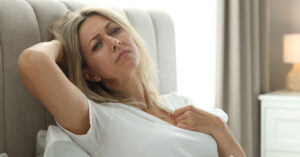 young woman experiencing hot flashes. Menopause at early age
