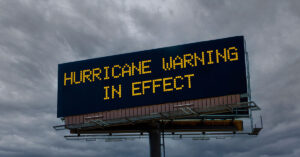 Desperate Searches for Loved Ones Still Continue After Hurricane Helene sign saying "Hurricane warning still in effect"