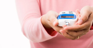 person using glucose monitor. Diabetes and blood sugar management concept