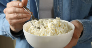 6 Reasons Why You Should Be Including Cottage Cheese In Your Diet man holding a bowl of cottage cheese