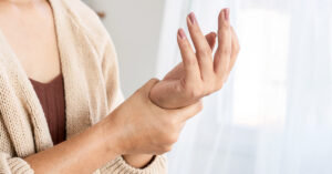 One Minute Test Could Reveal If You’re Living With a Worrying Disease woman holding her own hand in discomfort