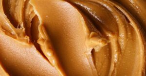 13 Recent Peanut Butter Recalls to Be Aware Of Close up of smooth peanut butter showing texture