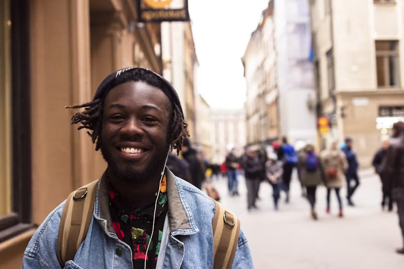 a young man smiling in public