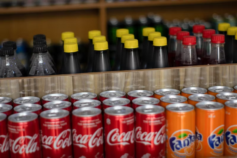 coca cola and fanta cans in a grocery store