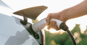 The Truth Behind 7 Popular Electric Car Myths charging plug being inserted into an electric car