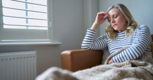 Long Covid Researcher Opens Up About Her Struggles With The Condition malaised woman placing hand on head