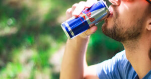 man drinking a red bull