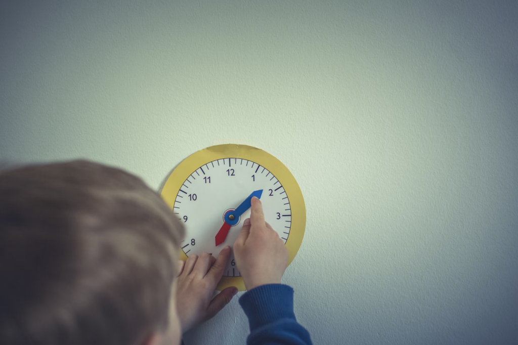 A young child interacts with a wall-mounted clock, pointing at the time. This image emphasizes the importance of recognizing and acting quickly on meningitis symptoms, as the disease can progress rapidly, making timely intervention crucial for effective treatment.