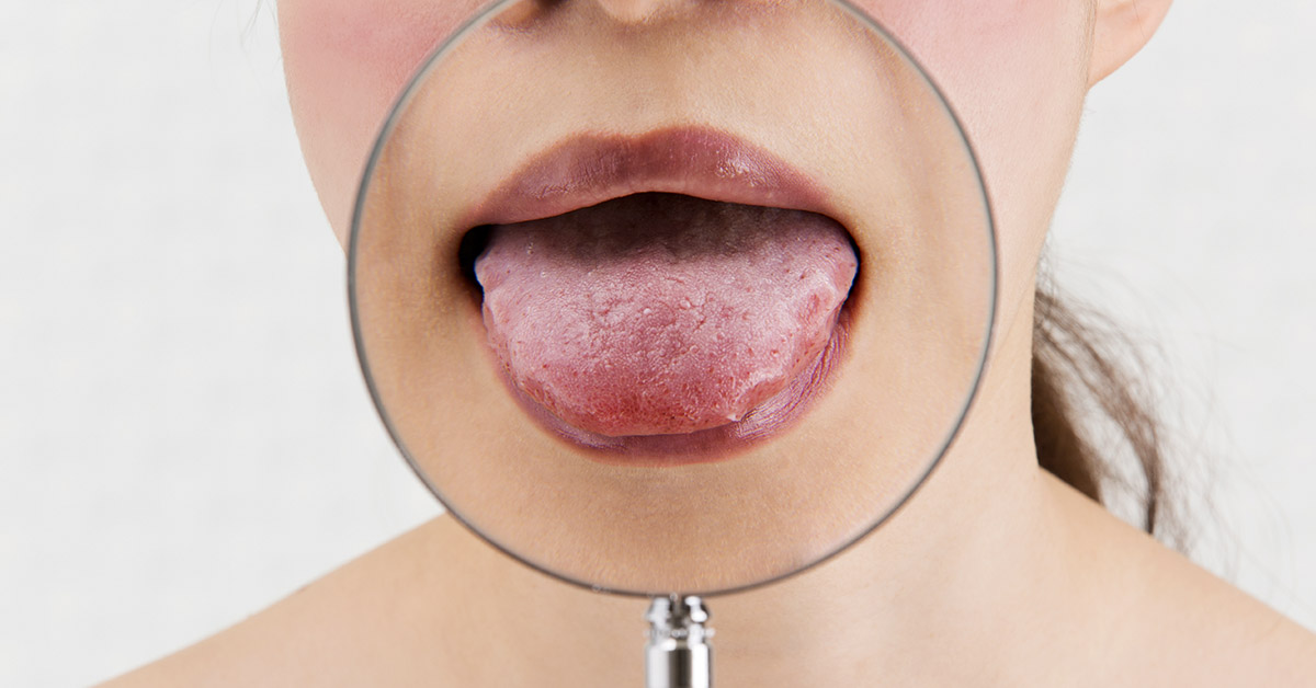 magnifying glass placed over woman's mouth with her tongue sticking out. Investigating Tongue health