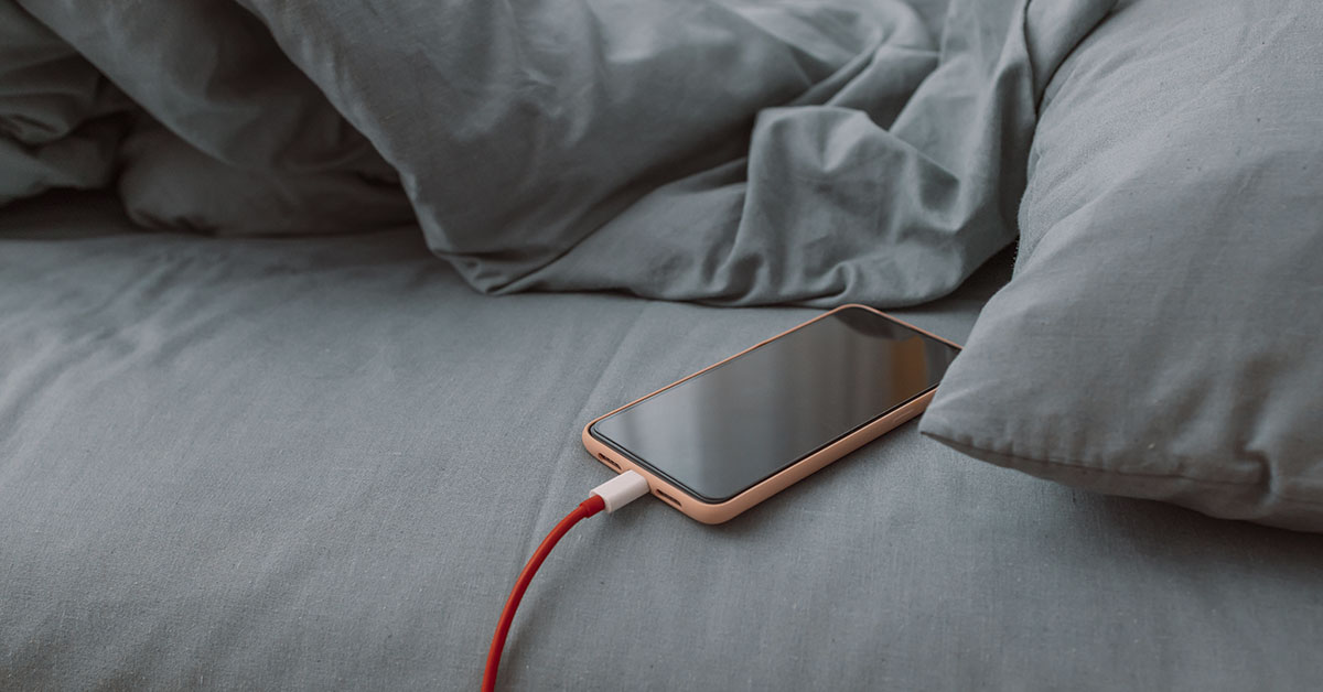 smartphone plugged in and charging on a couch