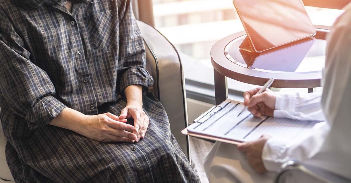 Doctor speaking with patient taking notes