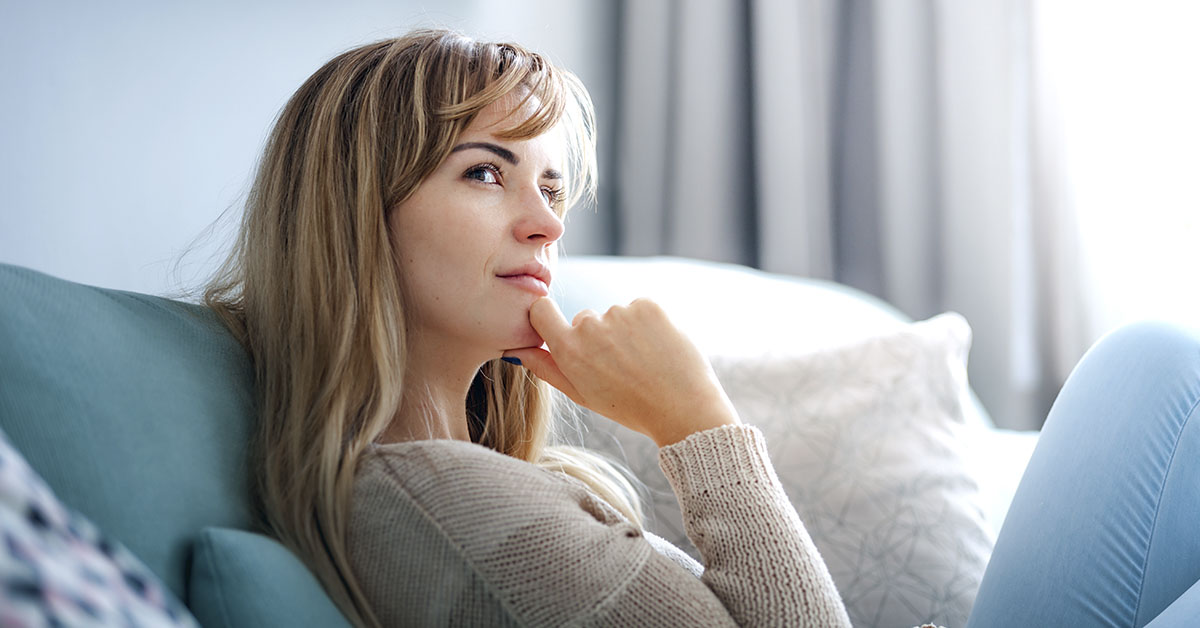 woman on couch pondering