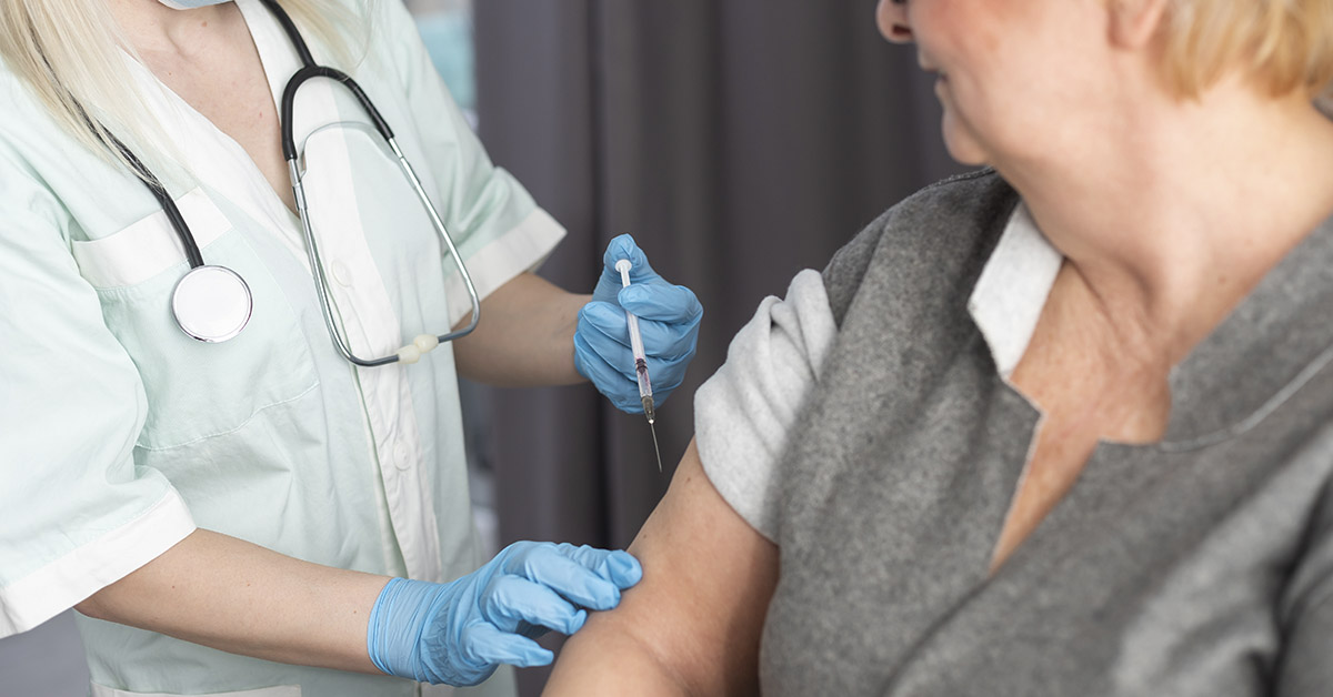 nurse administering a vaccine to a woman