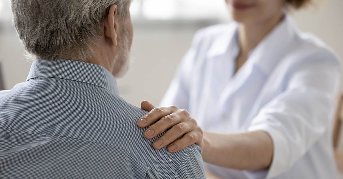 Doctor comforting patient and putting their hand on their shoulder