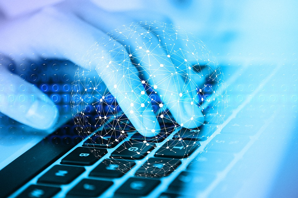 Person typing on laptop with digital network overlay, representing the data privacy concerns as bankrupt 23andMe's customer genetic information could be sold to new owners.