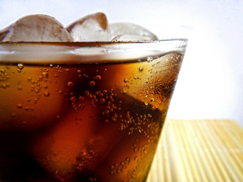 Close-up of cold carbonated cola with ice cubes showing the bubbles that mask extreme sweetness levels, as explained by Dr. Smith in his research on sensory manipulation in beverages.