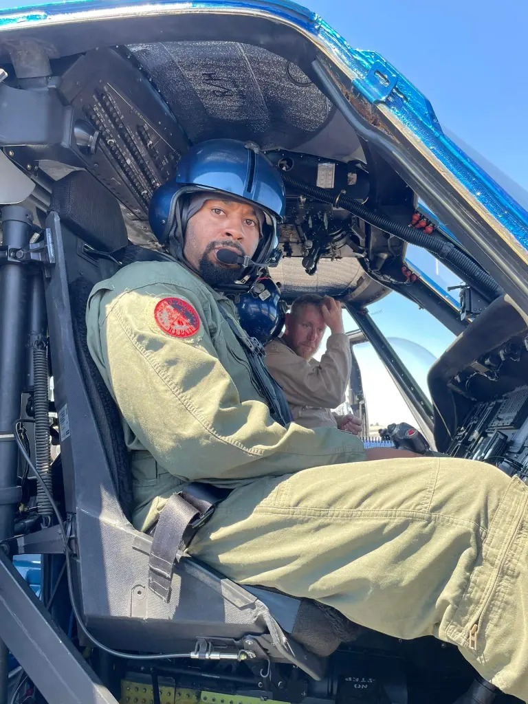 Pilot Sean Johnson seen in uniform, sitting inside a helicopter .