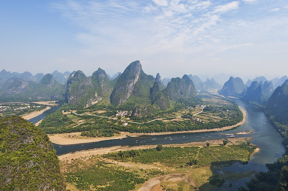 Dramatic limestone peaks and river landscape in southern China showcasing the region's distinctive karst topography.