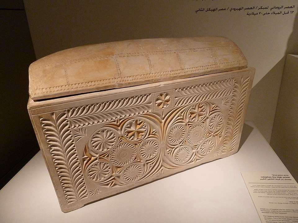 An ornately decorated ancient ossuary (bone box) displayed in a museum, similar to the Caiaphas ossuary discovered in 1990 that contained the remains of the high priest who played a role in Jesus's trial according to historical accounts.