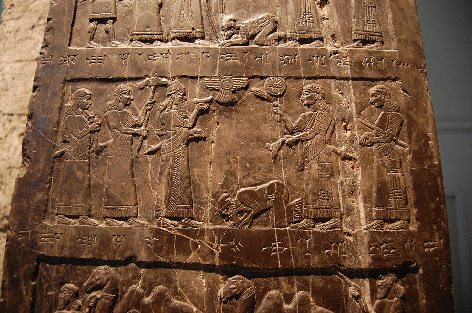 Ancient stone relief showing figures in formal Mesopotamian attire with cuneiform inscriptions, representative of artifacts like the Black Obelisk that depicts King Jehu, one of many Biblical Figures whose existence has been validated by archaeological discoveries.