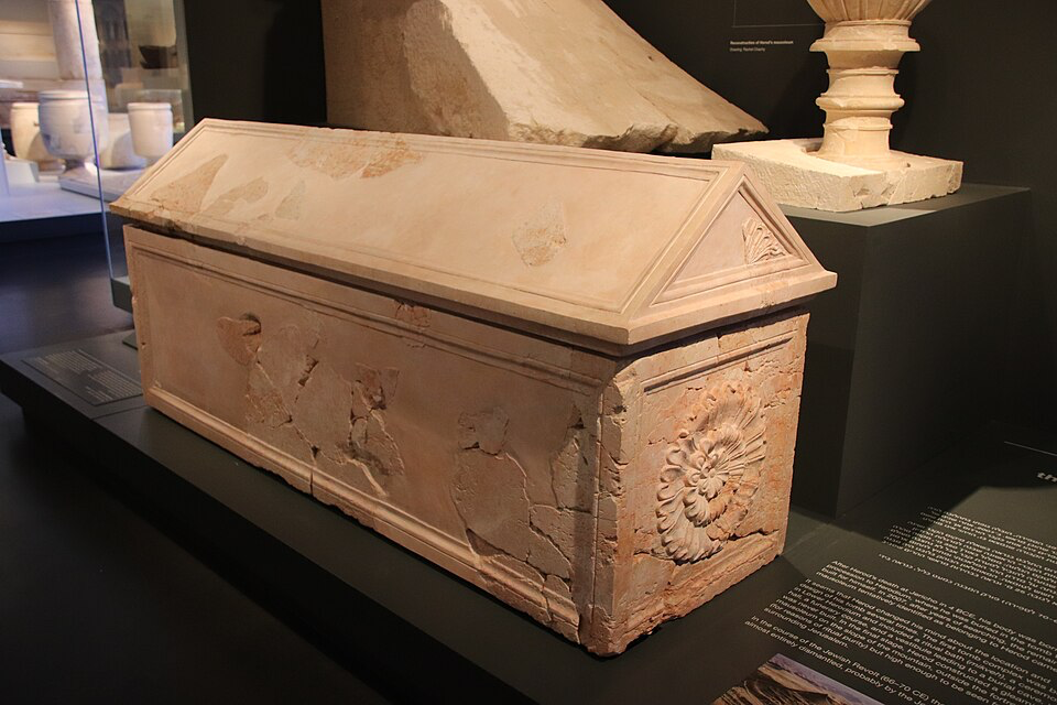 Ancient limestone sarcophagus displayed in a museum, representative of burial artifacts that provide archaeological evidence for historical characters, similar to royal tombs discovered in ancient Israel that confirm scriptural accounts.