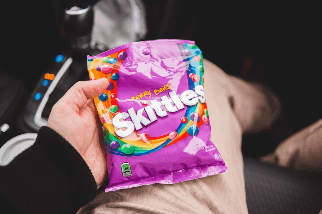 Crop person holding packaging of candies