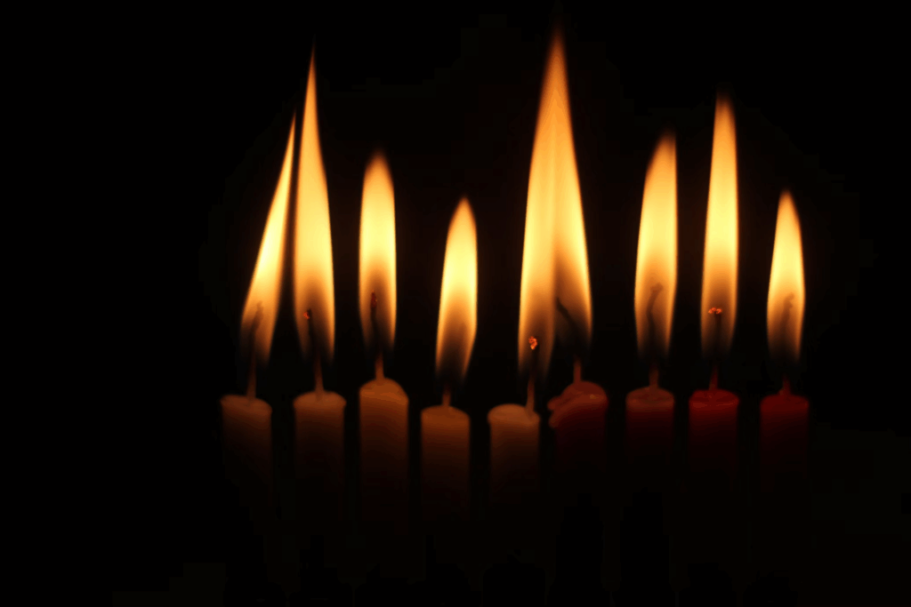Multiple candles burning brightly against darkness, symbolizing hope, remembrance, and the ongoing fight for survivors.