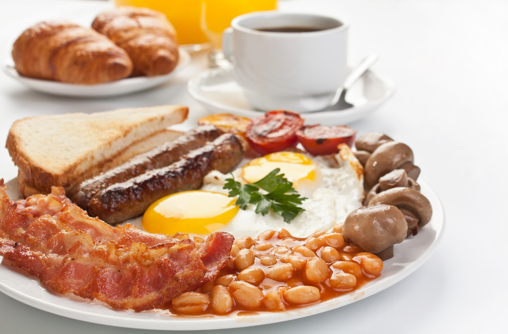 Traditional Full English Breakfast - sunny-side-up fried eggs, sausages, beans, mushrooms and bacon