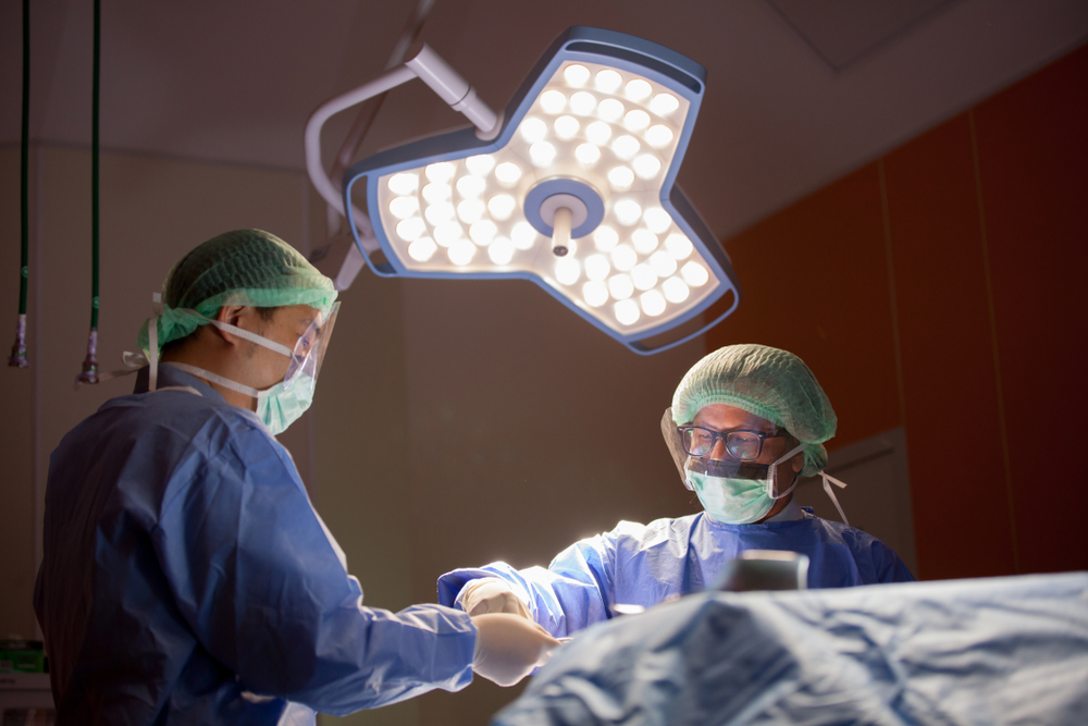 Concentrated doctor, assistant and nurse in a patient during a hysterectomy operation in a hospital