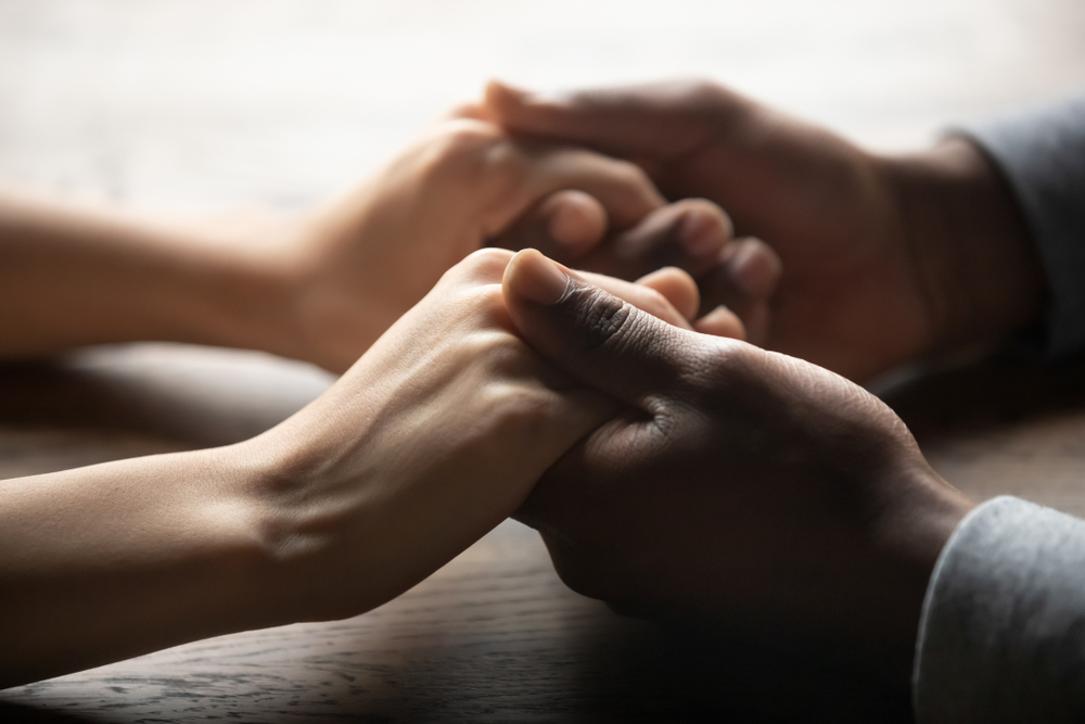 Mixed ethnicity family couple holding hands on table, black man friend husband support woman wife expressing love feelings, trust care honesty in interracial relationship concept, close up view