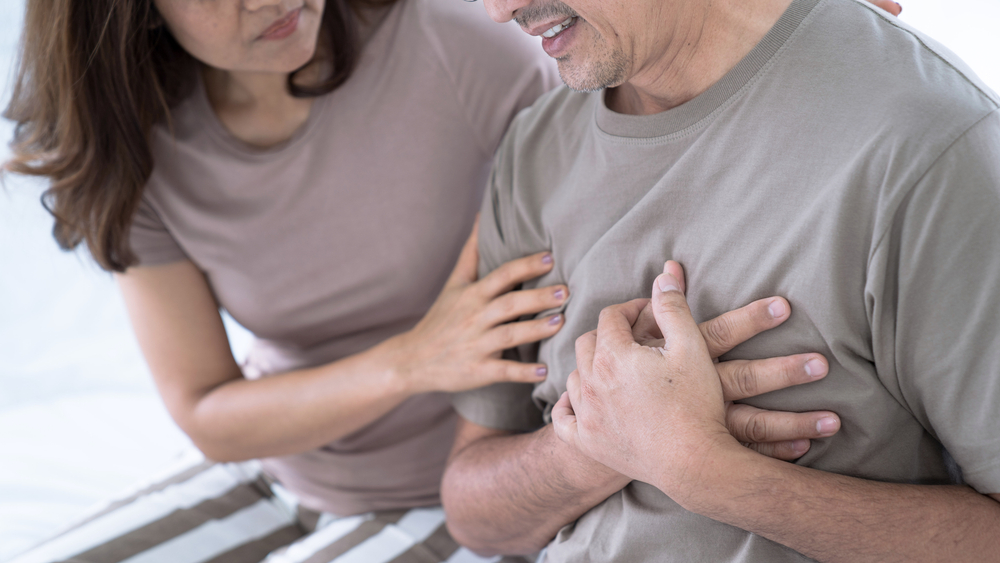 Elderly Asian man with chest pain from a heart attack, His wife was worried when she saw her husband sick, congenital disease, Heart disease, High blood pressure.
