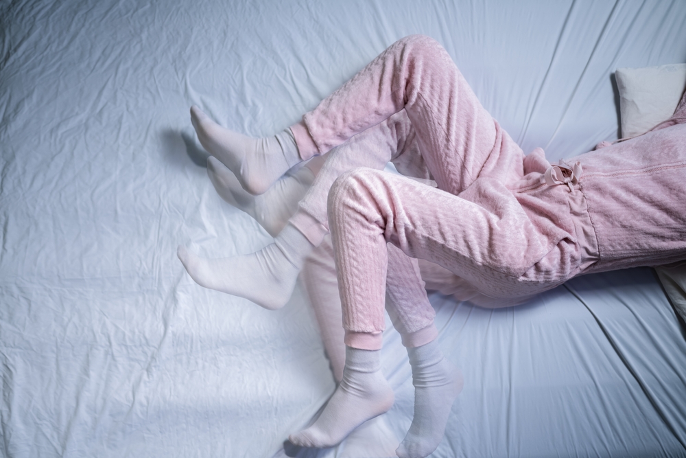 African American Woman With RLS - Restless Legs Syndrome. Sleeping In Bed