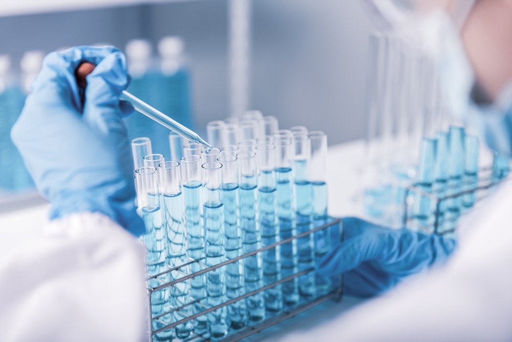 chemist,scientist hand dropping chemical liquid into test tube, science research and development concept
