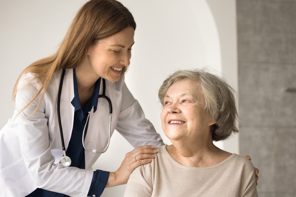 Friendly young female doctor give support to retired woman congratulate on recovery, express care and understanding. Happy senior satisfied by good medical services in hospital. Geriatrics, healthcare
