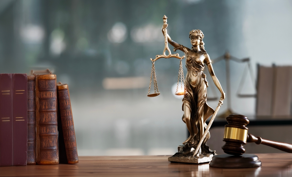 Legal and law concept. Statue of Lady Justice with scales of justice and wooden judge gavel on wooden table. Panoramic image statue of lady justice.
