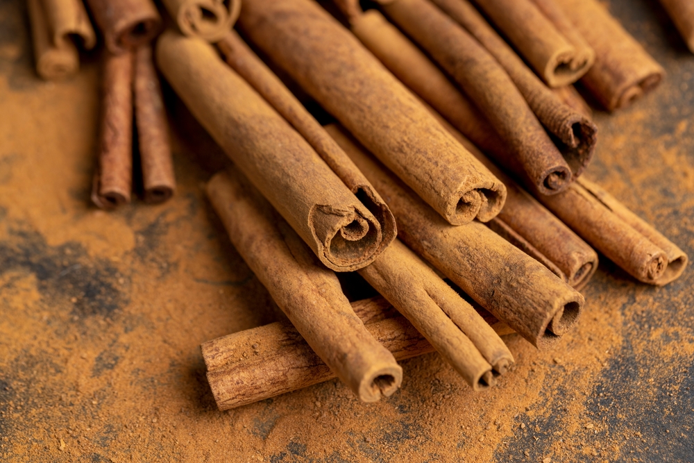 whole spice cinnamon and powdered cinnamon , whole shelf and ground cinnamon on the table