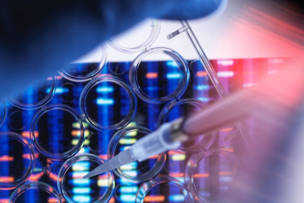 Scientist pipetting sample in multi well plate for DNA analysis with genetic results in background