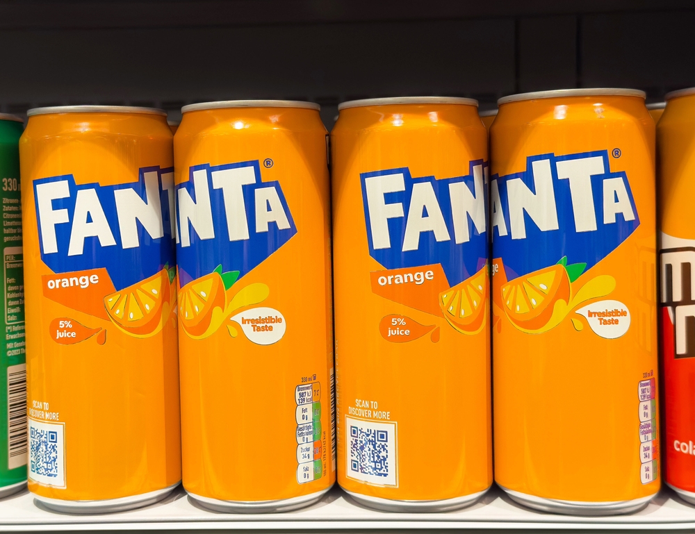 Villach, Austria - February 7, 2025: Fanta orange soda cans displayed on store shelf.