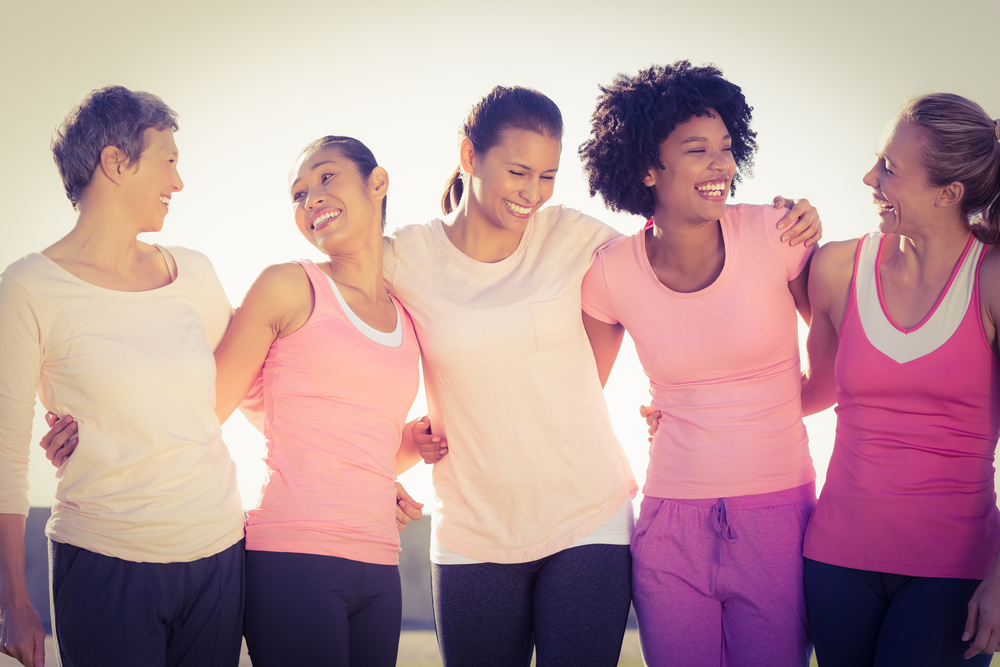 Laughing women wearing pink for breast cancer in parkland
