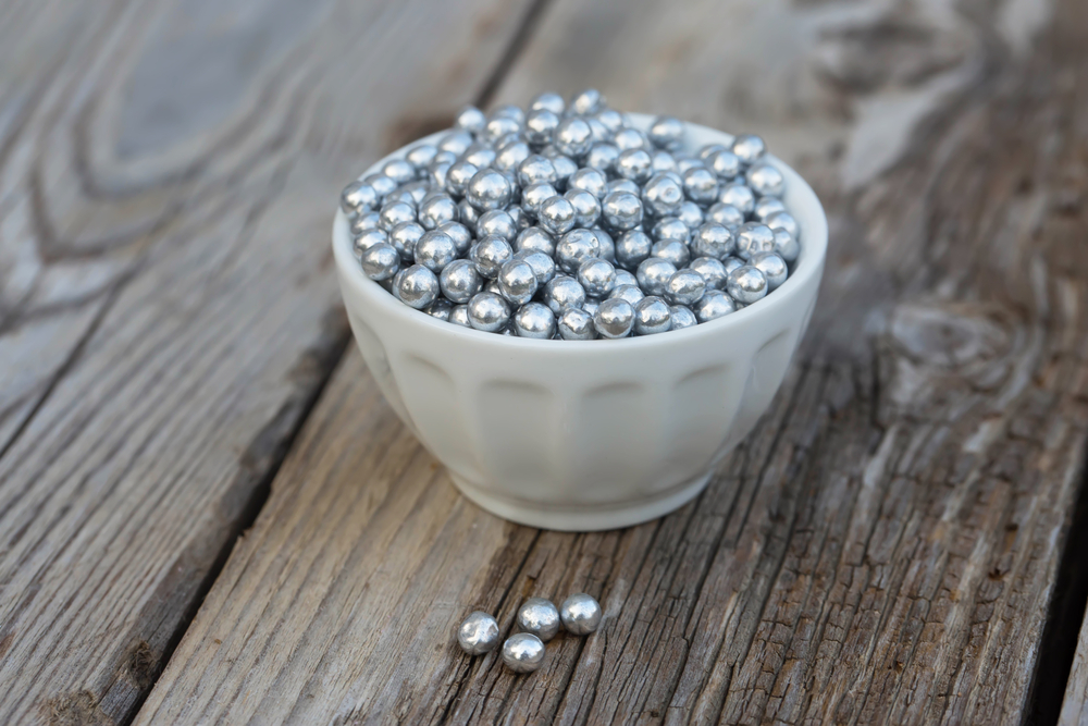 Silver sugar sprinkles in a bowl. Natural light. Selective focus.