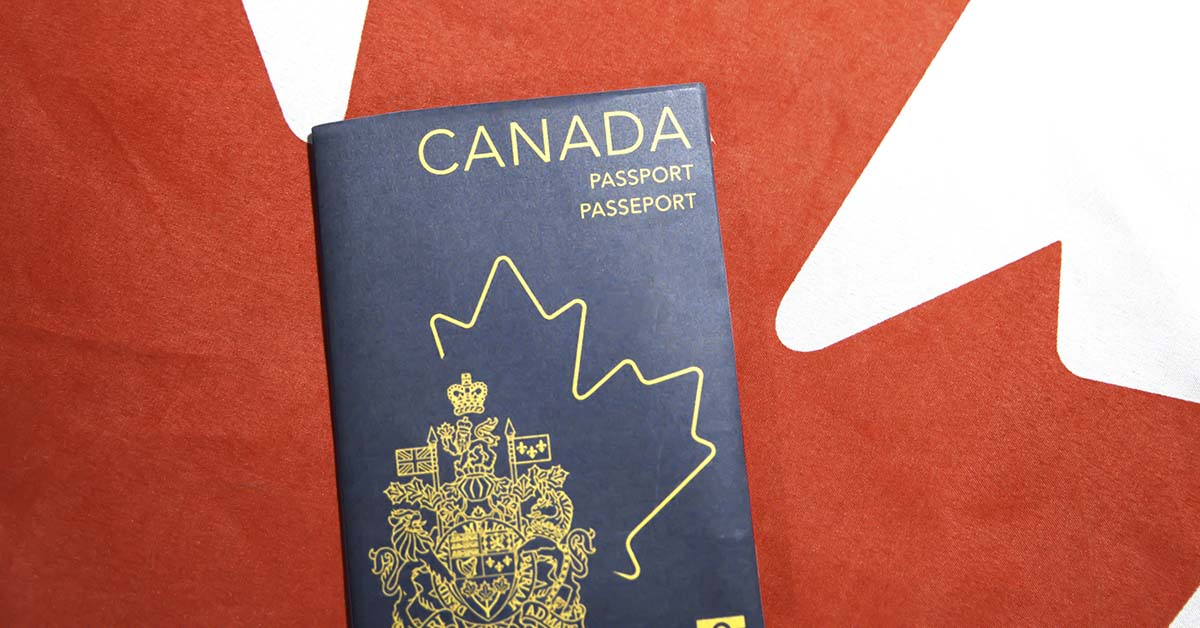 Canadian Passport with Canadian flag in background. Canadian tourists and travel concept.